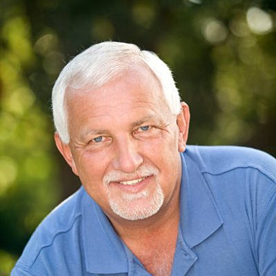 A handsome white haired mature man with moustache and goatee.